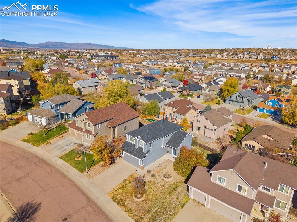 Image 34 of 47: Aerial view of residential area featuring mountains