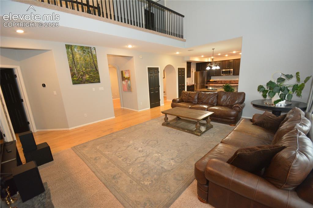 Image 17 of 48: main level family room. looking from fireplace toward eat in kitchen.