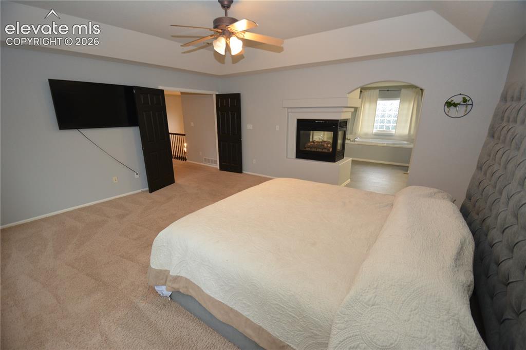 Image 27 of 48: Primary Bedroom, primary bath, 3 sided gas fireplace