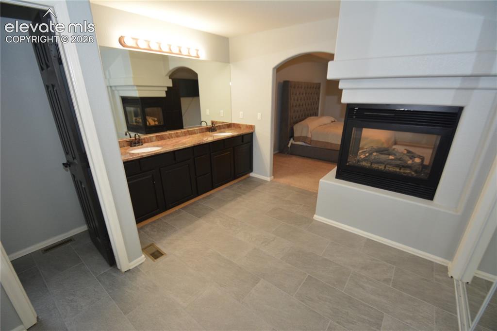 Image 30 of 48: primary bath, 3 sided fireplace.