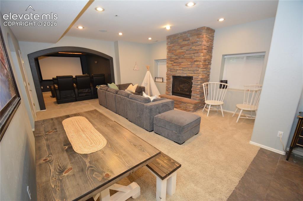 Image 40 of 48: Basement living room with gas fireplace.