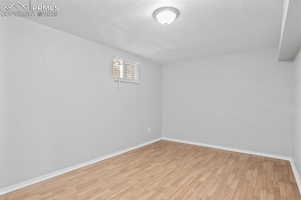 Image 10 of 25: Below grade area featuring light wood-style flooring and a textured ceiling