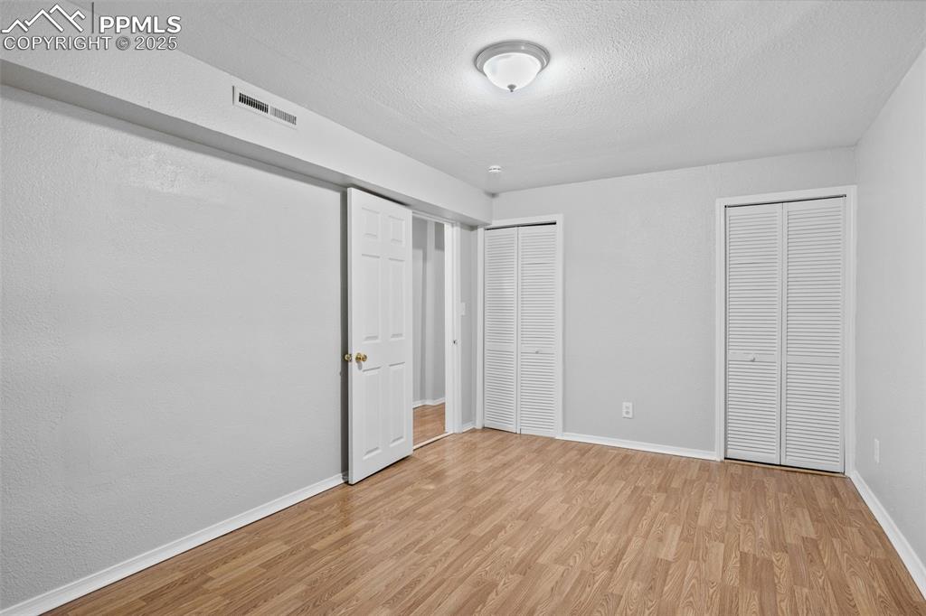 Image 11 of 25: Unfurnished bedroom featuring two closets, light wood-type flooring, and a 