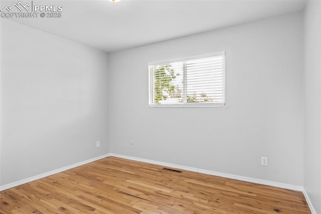 Image 13 of 25: Unfurnished room with wood finished floors and baseboards