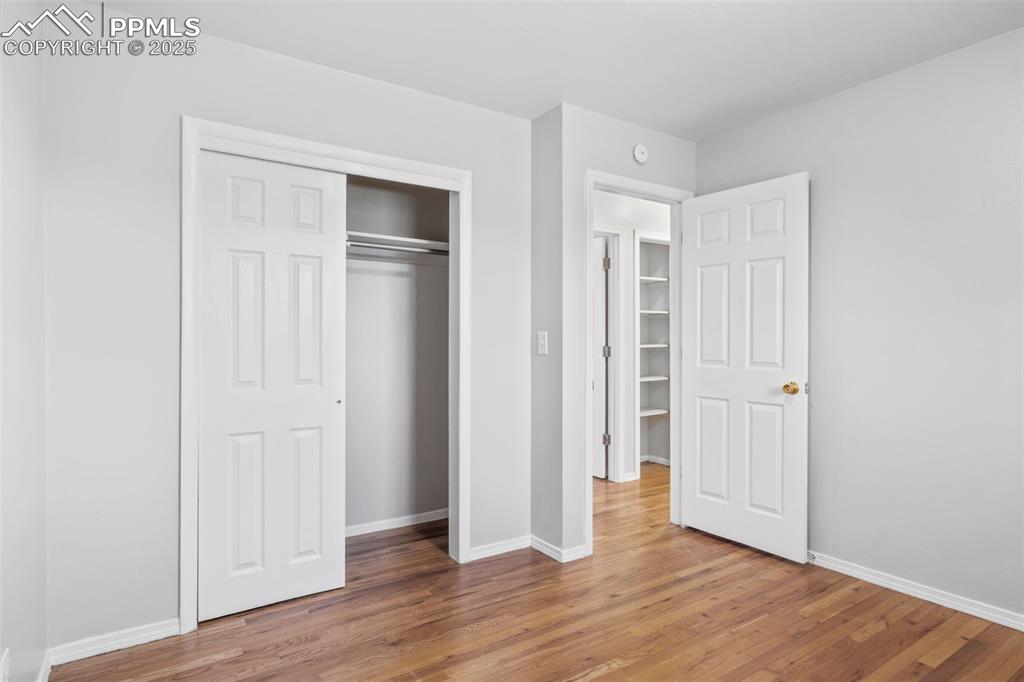 Image 14 of 25: Bedroom featuring light wood finished floors and a closet