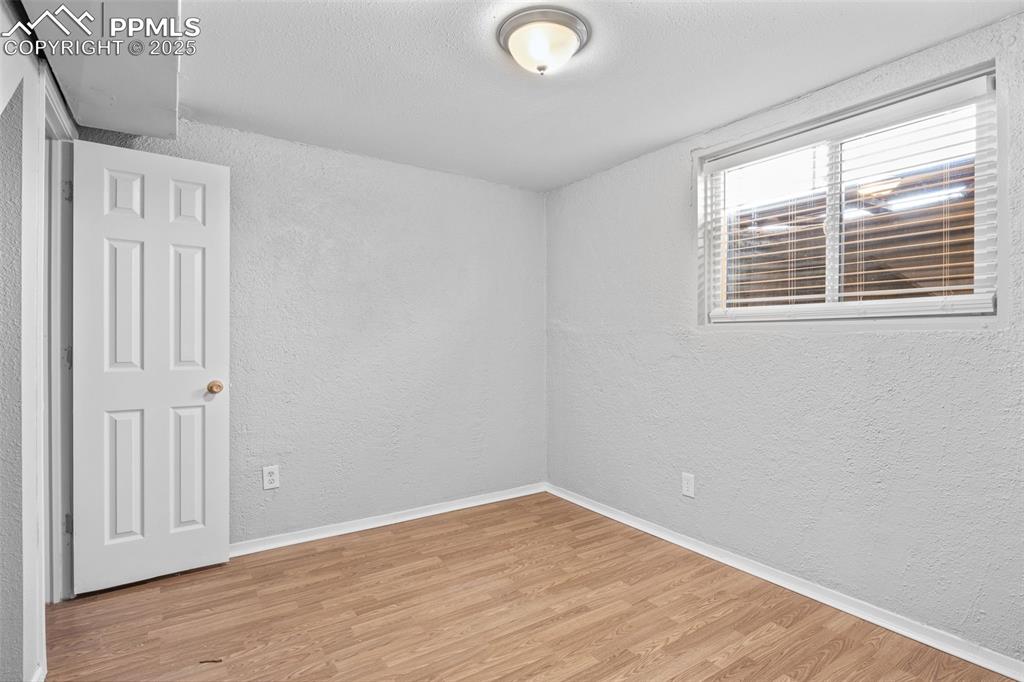 Image 19 of 25: Unfurnished room featuring a textured wall, light wood finished floors, and