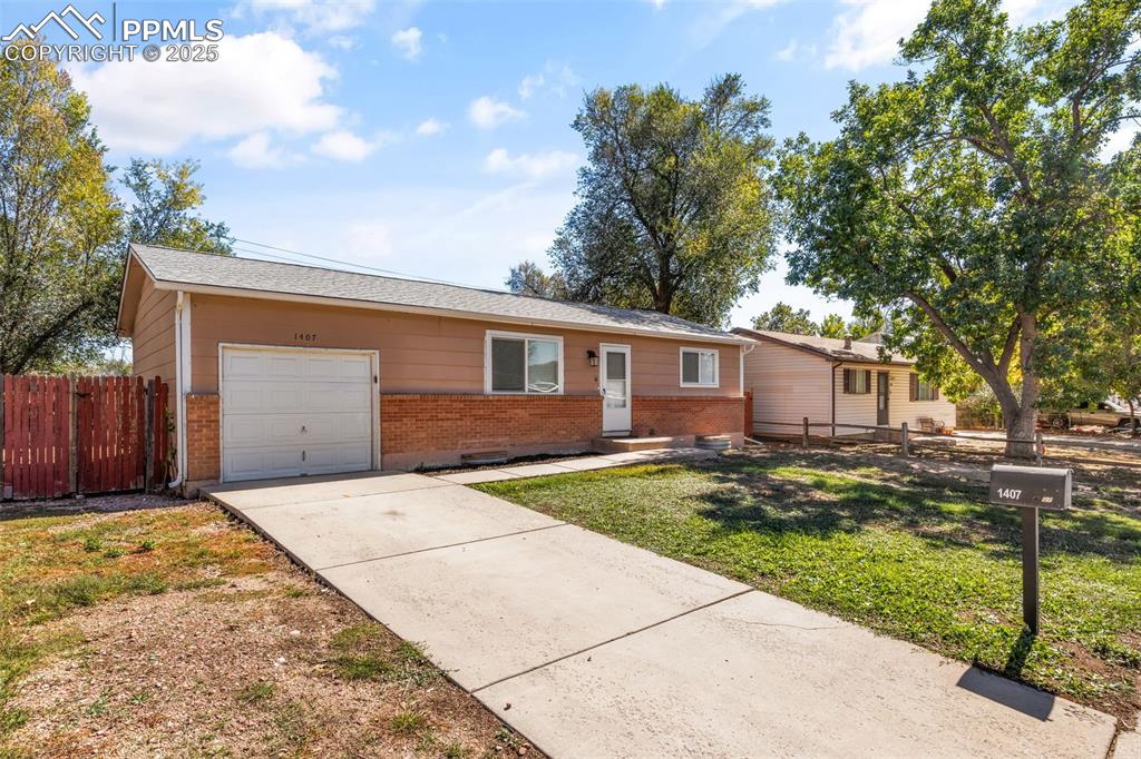 Image 2 of 25: Single story home with brick siding, driveway, and an attached garage