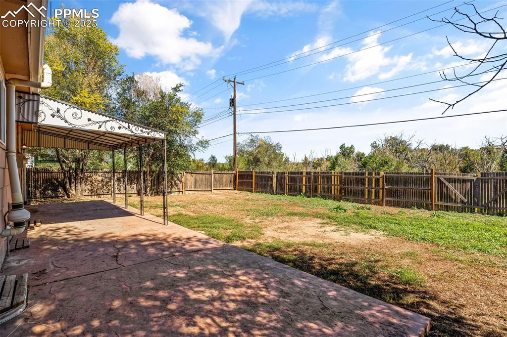 Image 22 of 25: Fenced backyard featuring a patio