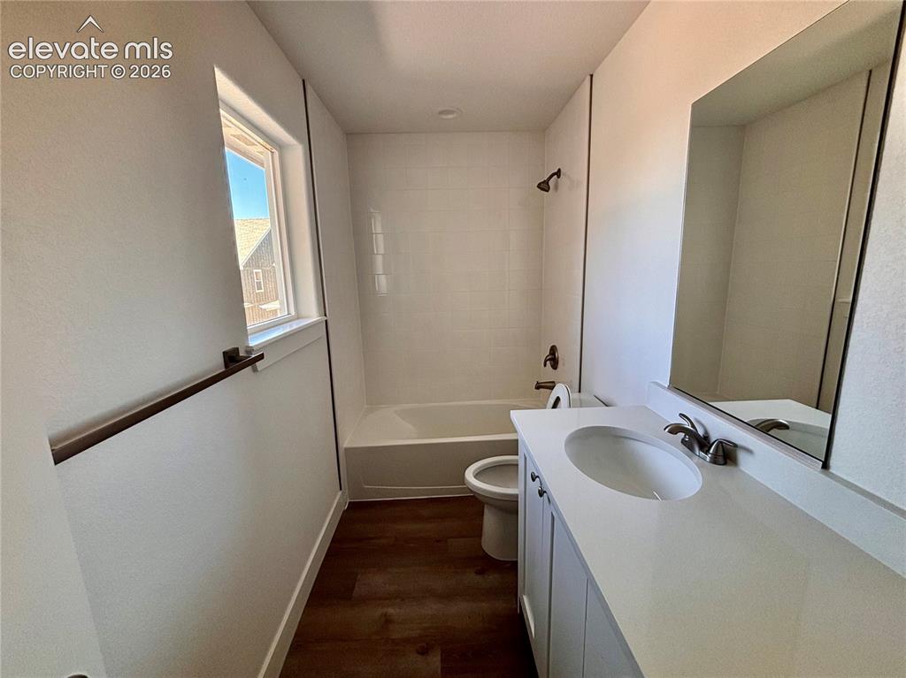 Image 11 of 20: Contemporary bathroom with a single window, white subway tile shower surrou