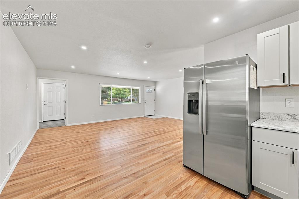 Image 12 of 49: Open concept living area featuring hardwood flooring, recessed lighting, wh