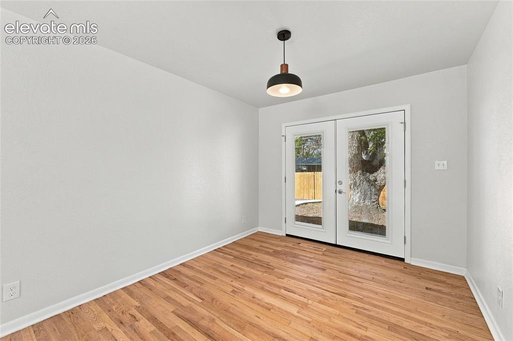 Image 14 of 49: Hardwood flooring, painted walls, contemporary pendant light, and double gl