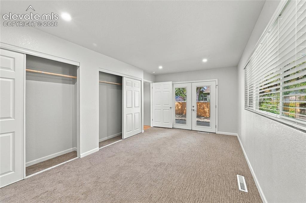 Image 16 of 49: Recessed lighting, light-toned carpeting, dual pane windows with blinds, an