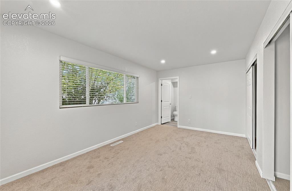 Image 17 of 49: Recessed lighting, light-colored carpeting, horizontal window blinds, and s