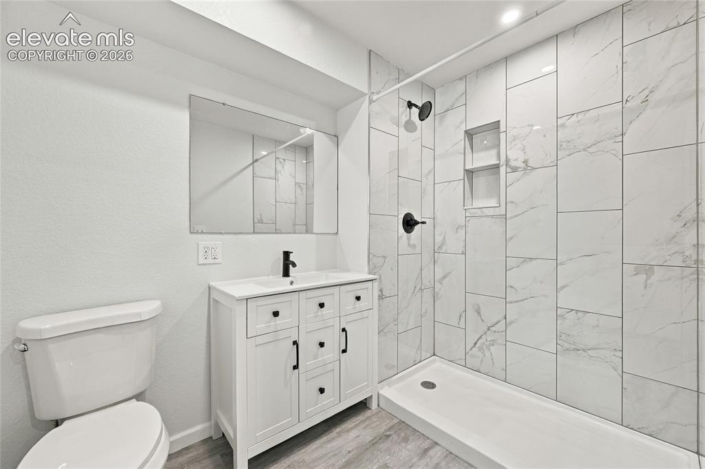 Image 18 of 49: Walk-in shower with vertical tile and built-in niches