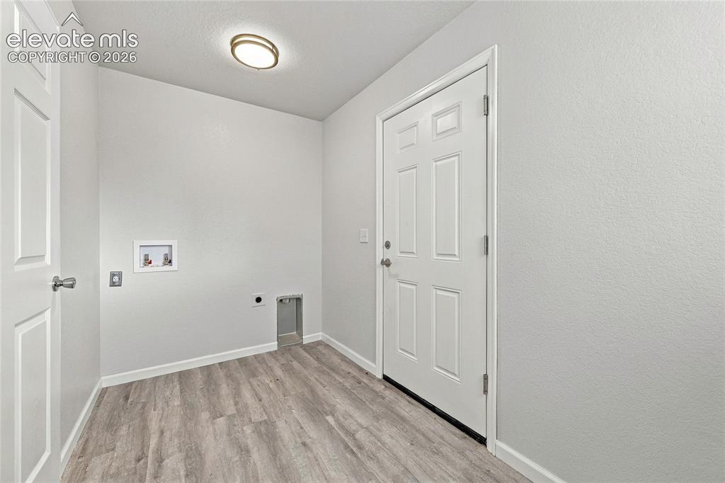 Image 19 of 49: Neutral wall paint, wood-finish flooring, overhead flush mount lighting, la
