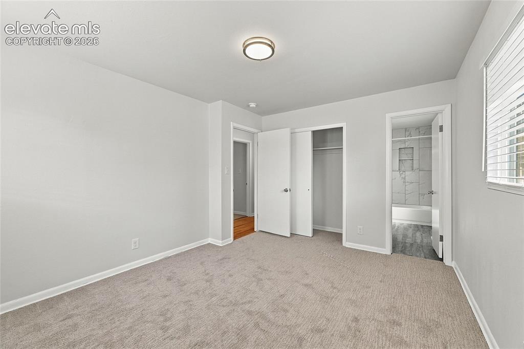 Image 22 of 49: Plush carpeting, recessed lighting, and a window with blinds