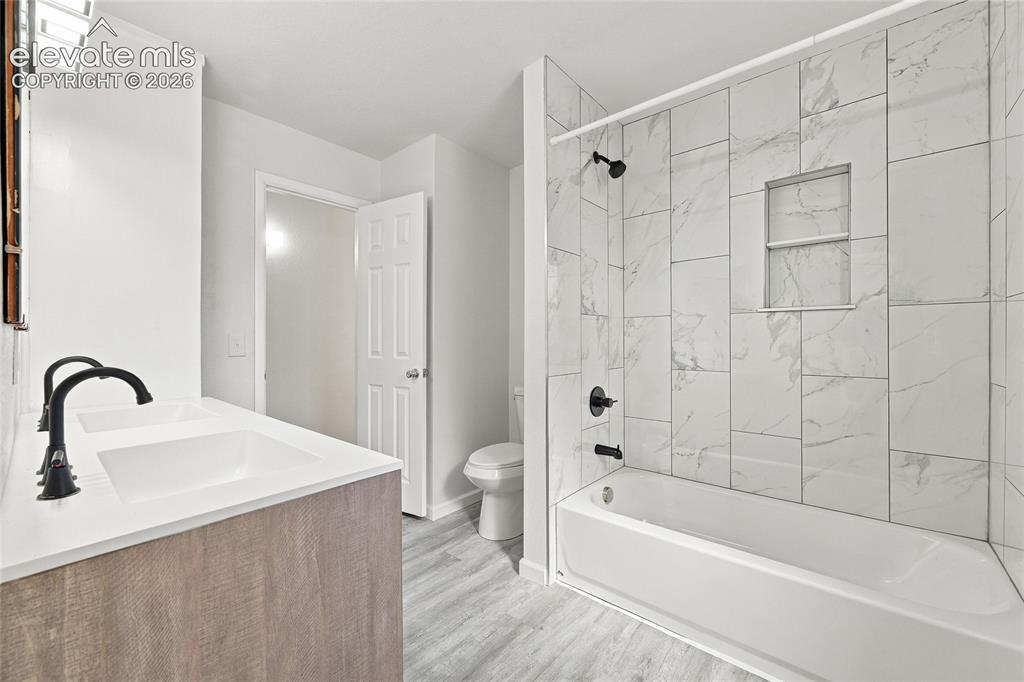 Image 23 of 49: Dual vanity with matte black faucets, white countertop, wood-finish cabinet