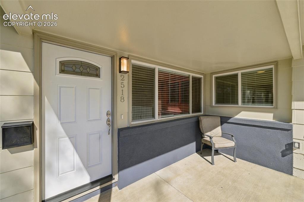 Image 3 of 49: Covered entryway featuring a white paneled door with decorative glass, an e