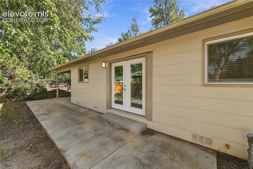 Image 31 of 49: Rear exterior featuring horizontal siding, a covered patio, a concrete pati