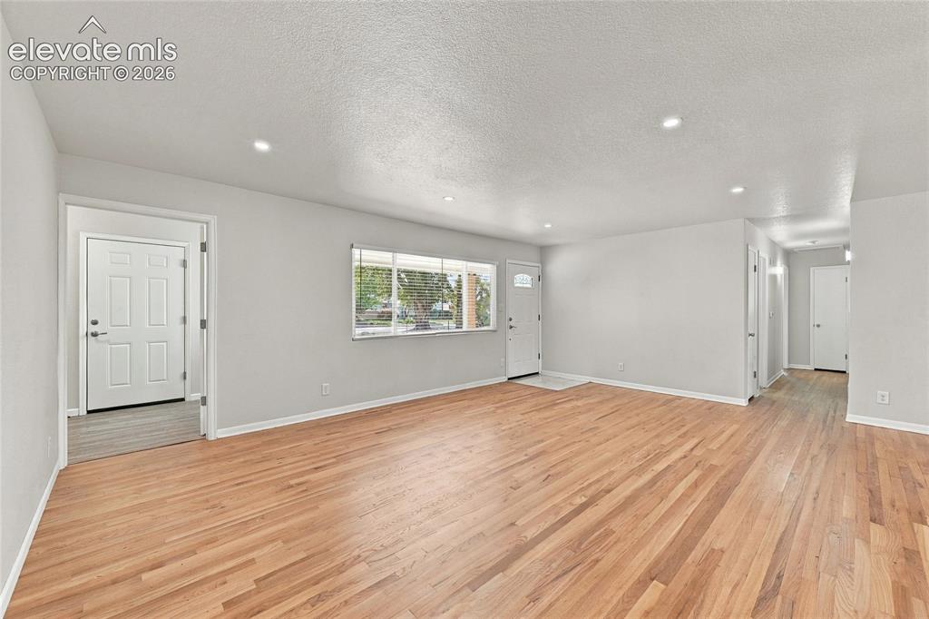 Image 6 of 49: Hardwood flooring, recessed lighting, multiple entryways, and a multi-pane