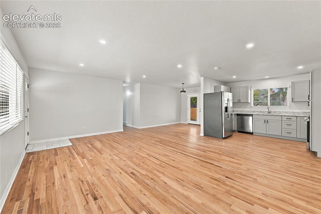 Image 7 of 49: Open-concept living area with hardwood flooring throughout