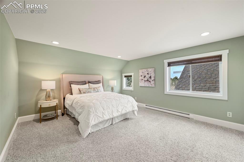 Image 17 of 50: Expansive primary bedroom with solar blinds.