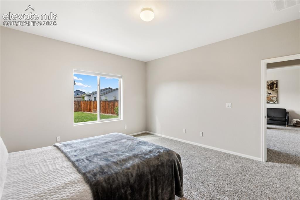 Image 32 of 46: Spacious primary bedroom with room darkening shades