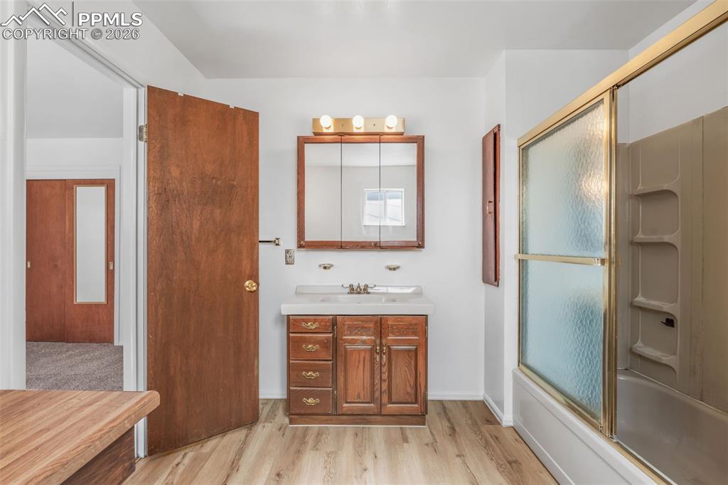Image 10 of 18: Full bathroom featuring vanity, light wood finished floors, and shower / ba