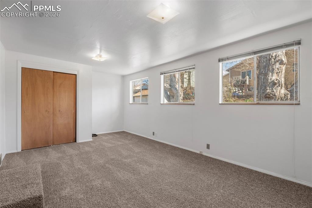 Image 13 of 18: Bedroom 2 featuring a closet, plenty of windows and new carpeted floors