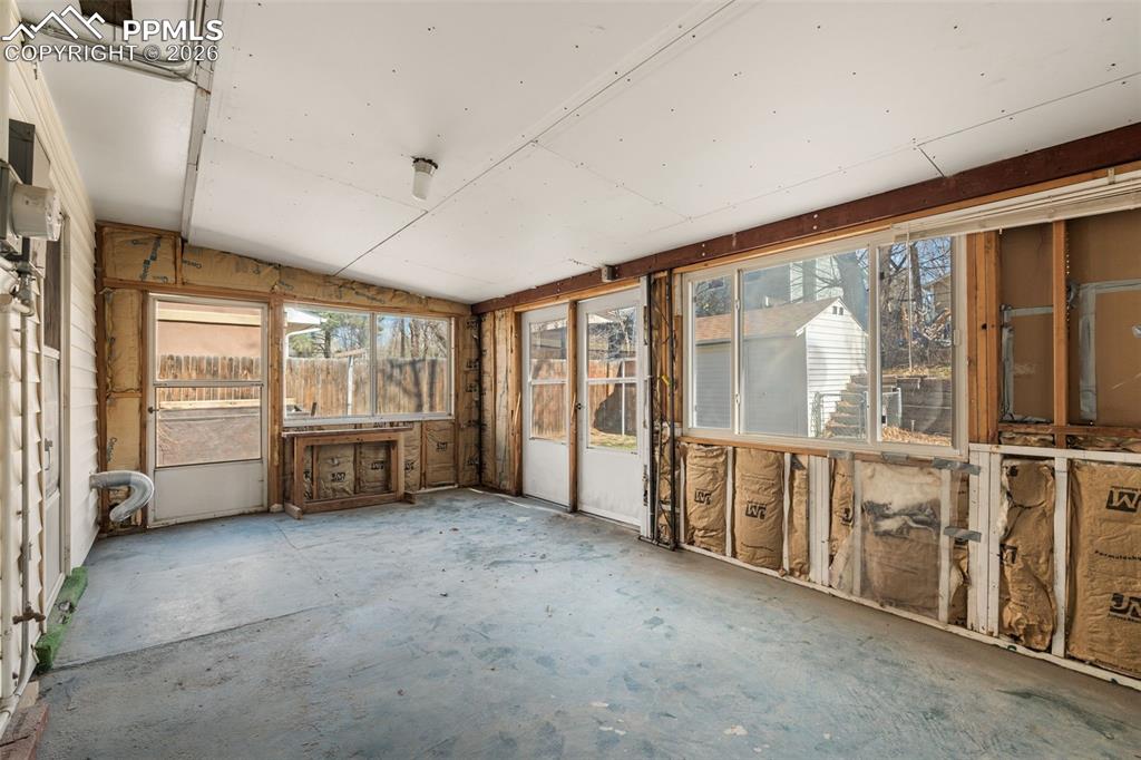 Image 14 of 18: Unfurnished sunroom with lofted ceiling and concrete flooring