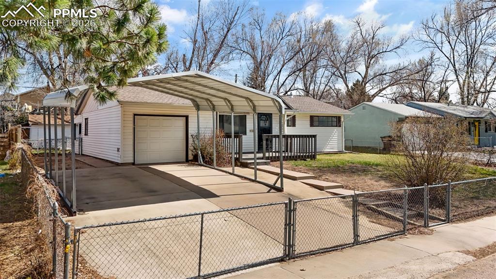 Image 2 of 18: Ranch-style house with a fenced front yard, a gate, concrete driveway, a ca