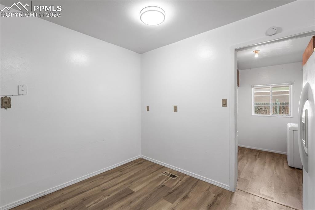 Image 6 of 18: Laundry room featuring wood finished floors and washer / clothes dryer