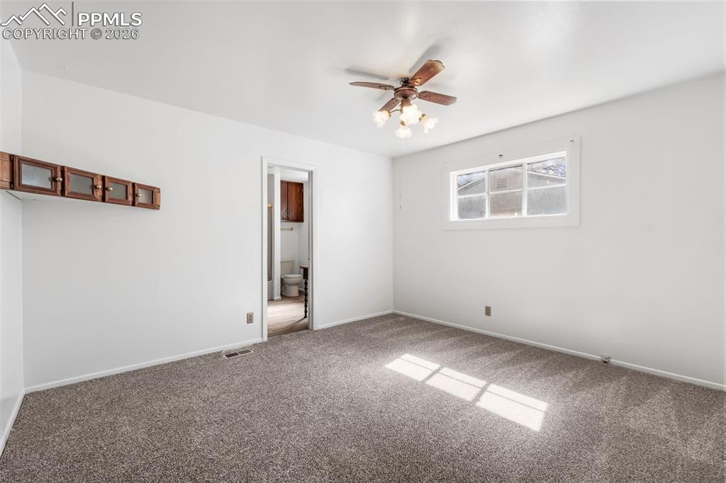 Image 9 of 18: Primary bedroom featuring carpet floors and a ceiling fan