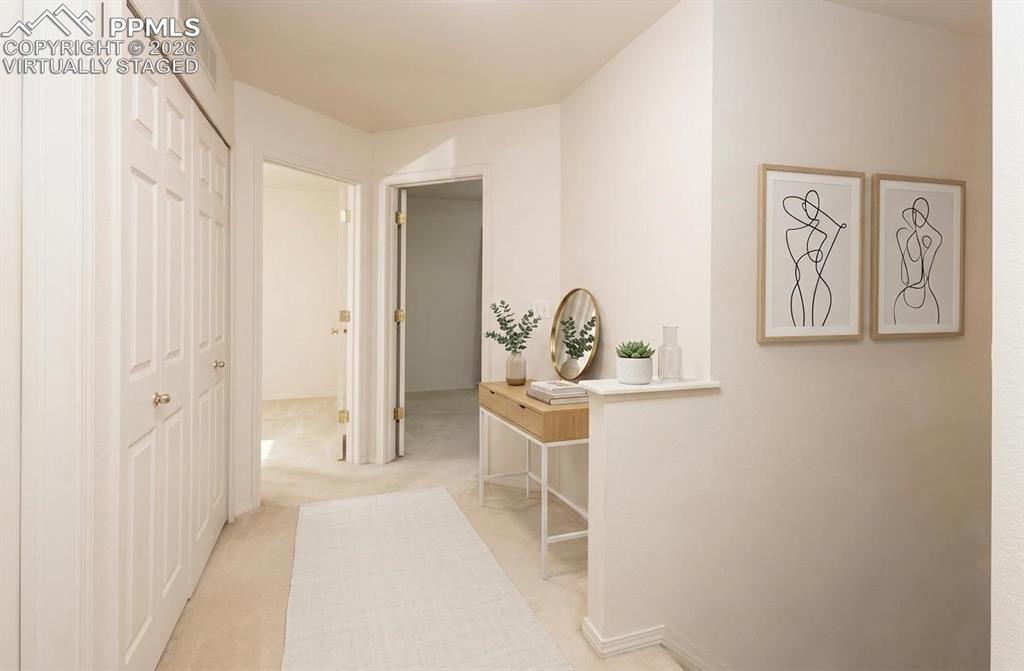 Image 12 of 35: Virtually Staged  Hallway featuring light neutral-toned walls, carpet floor