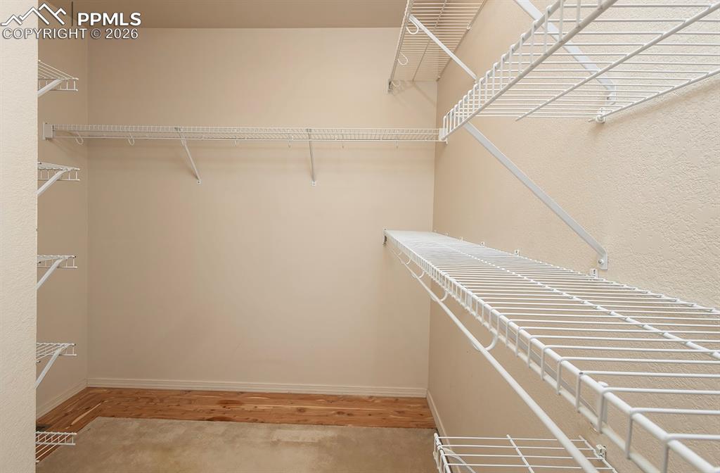 Image 15 of 35: Walk-in closet featuring wire shelving, wire hanging rods, and a blend of c