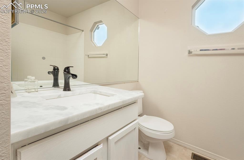 Image 17 of 35: Bathroom vanity featuring a built-in sink, stone countertop, and dark-finis