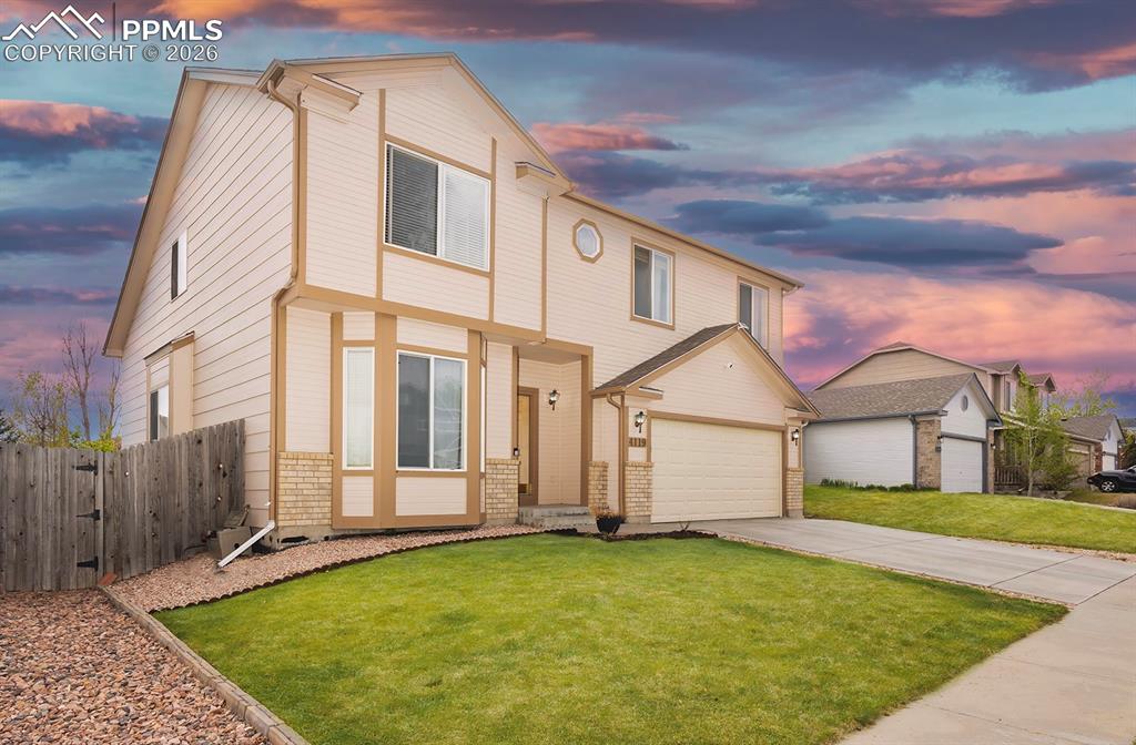 Image 23 of 35: Two-story residence featuring light-colored siding with contrasting trim, a