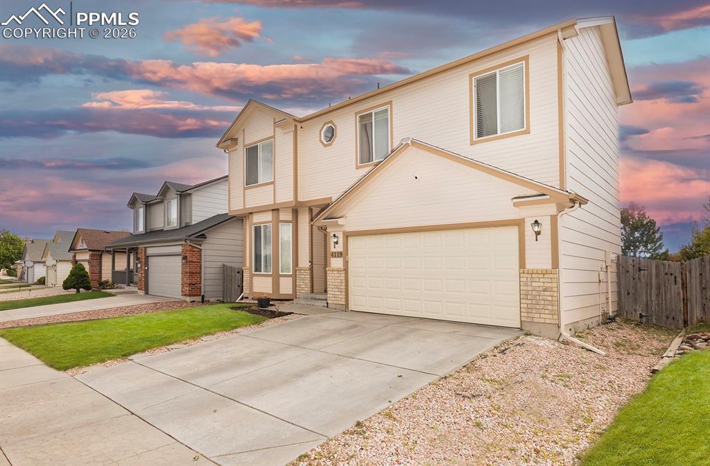 Image 24 of 35: Two-story residence featuring light-colored siding with contrasting trim, a