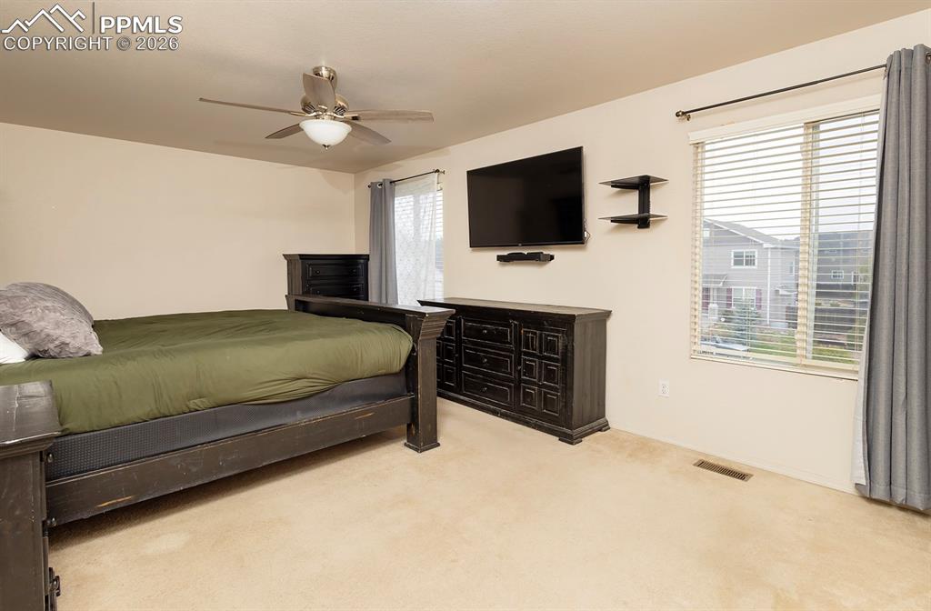 Image 29 of 35: Neutral-toned room featuring a ceiling fan with integrated lighting