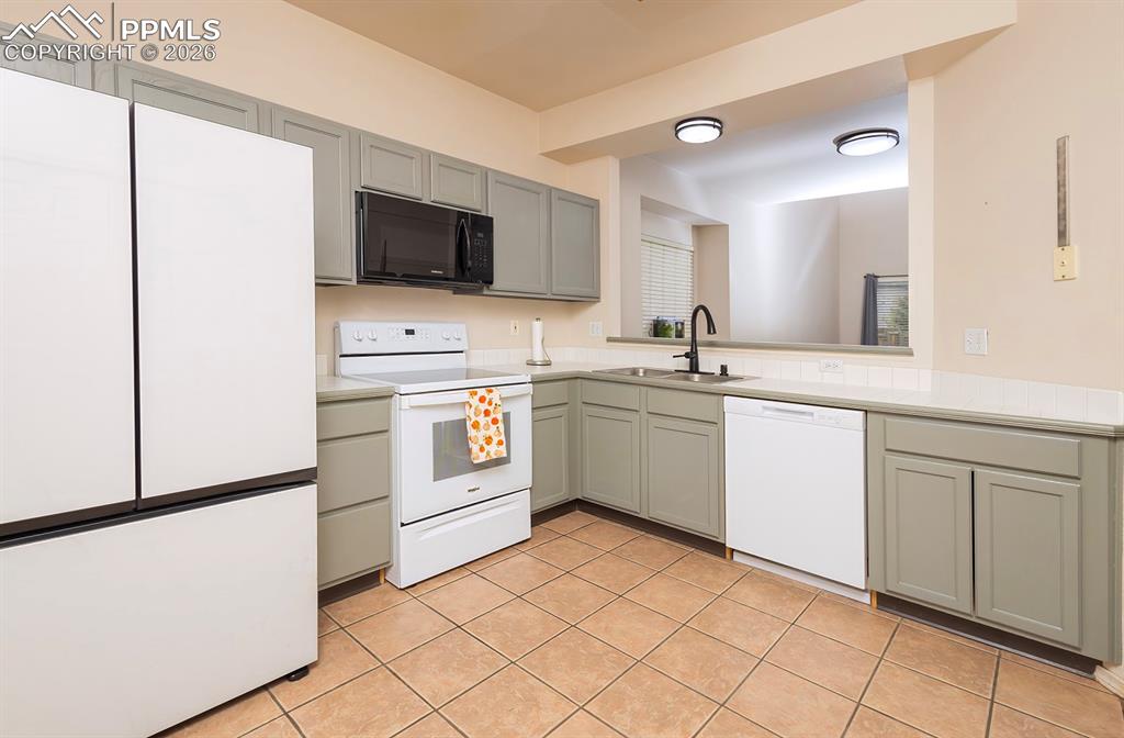 Image 4 of 35: Kitchen featuring tile flooring, white countertops, gray cabinetry, and a p
