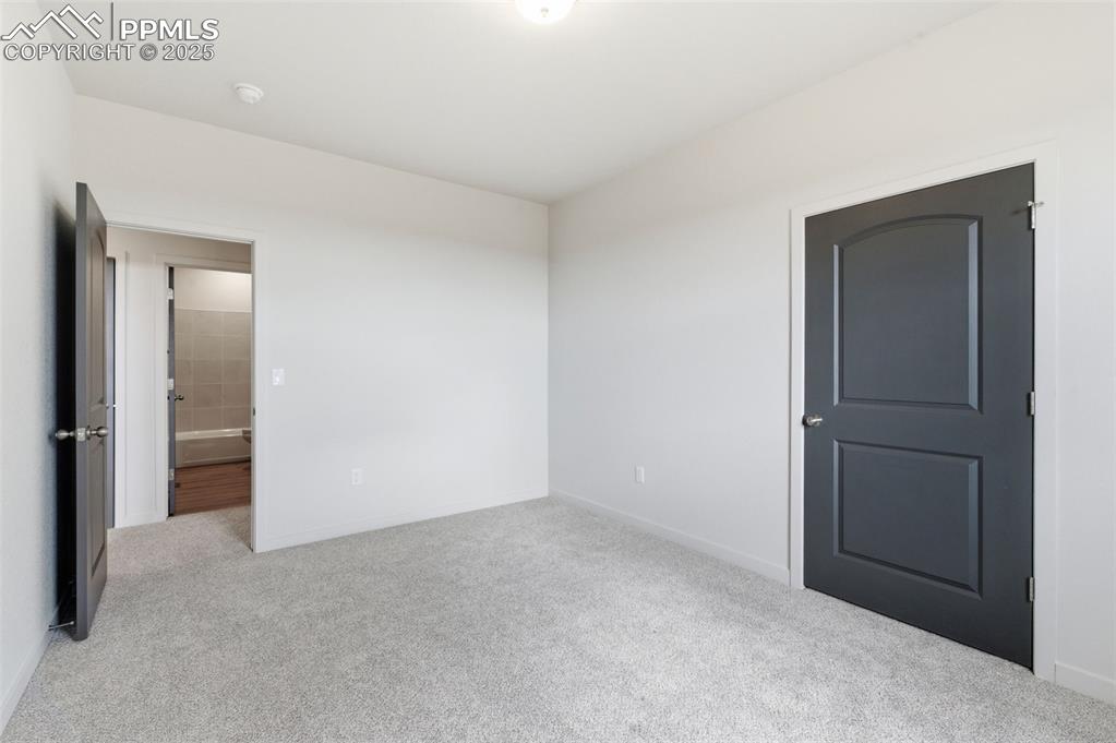 Image 23 of 24: Unfurnished bedroom featuring light colored carpet and baseboards