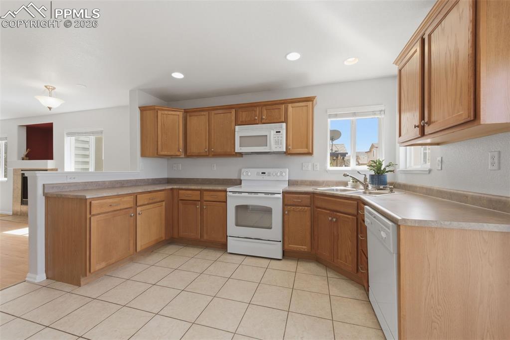 Image 15 of 34: Kitchen featuring light-tone wood cabinetry, laminate countertops, a built-