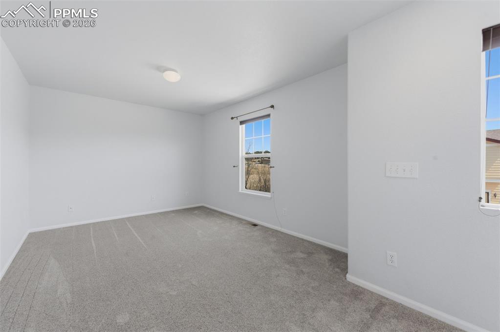 Image 20 of 34: Bright interior Loft space featuring light gray carpeting, neutral wall pai