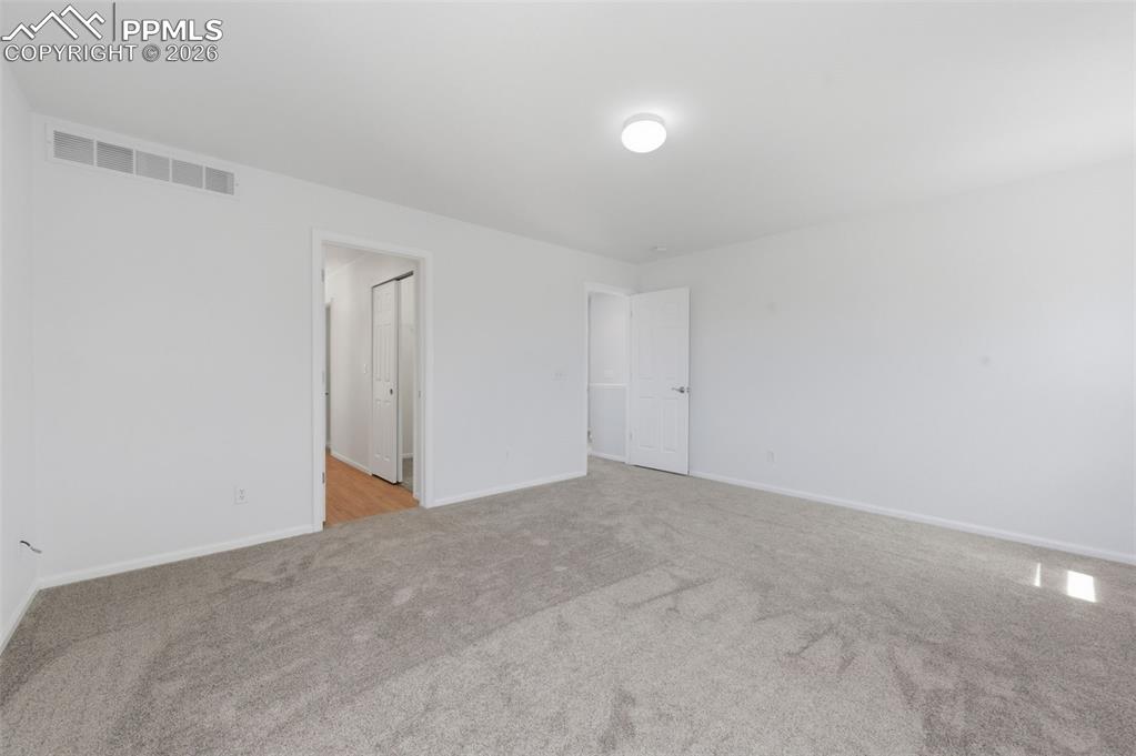 Image 23 of 34: Spacious room featuring light grey carpeting, white walls, and a flush-moun