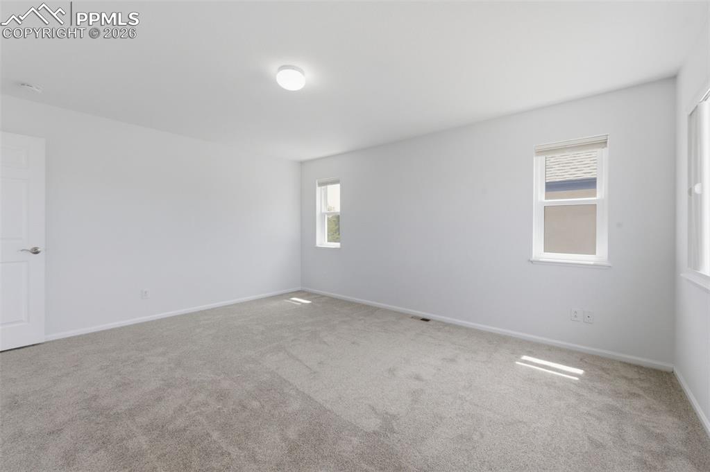 Image 24 of 34: Spacious room featuring light gray carpeting and white walls