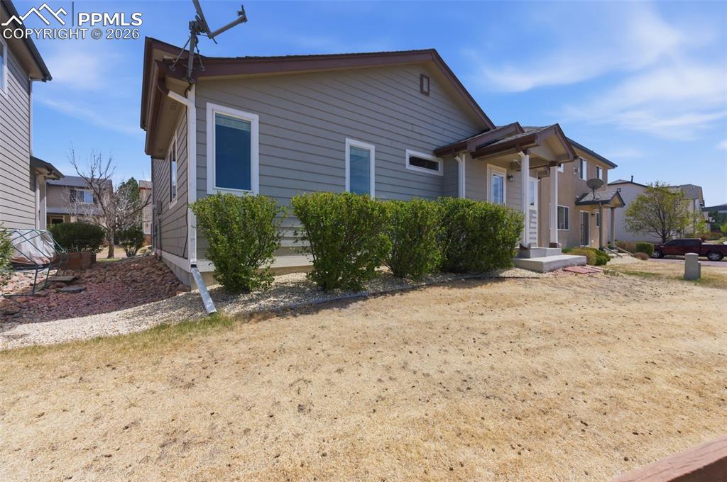 Image 28 of 34: Multi-level structure with neutral siding and white-framed windows