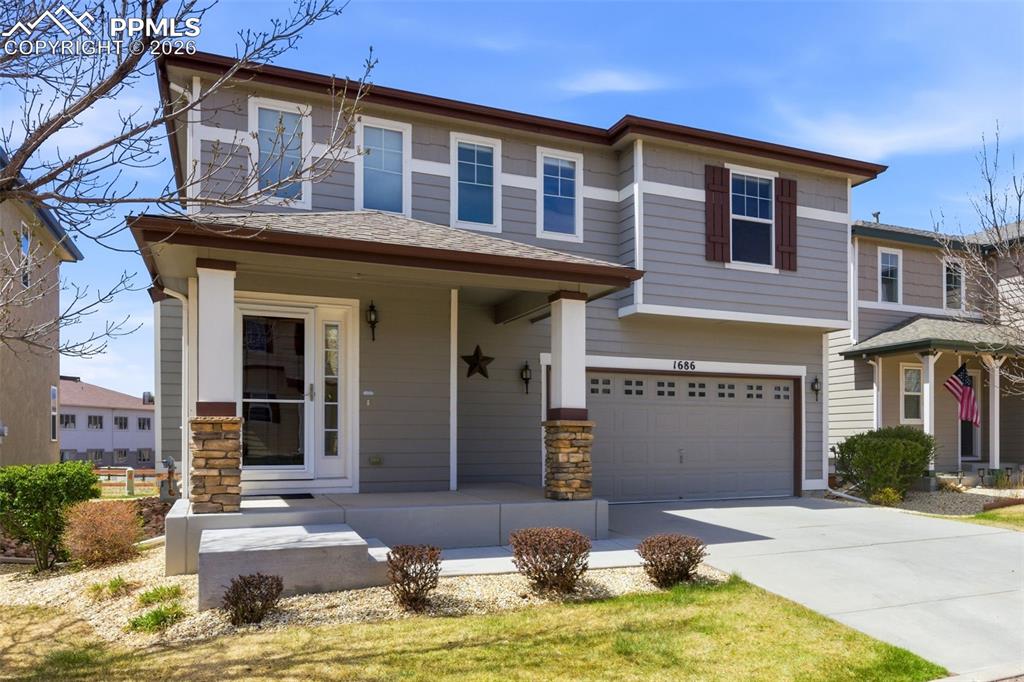Image 29 of 34: Two-story residence featuring grey siding with white trim, a covered front 