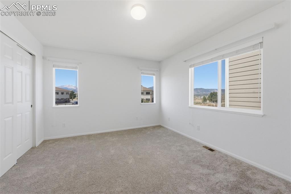 Image 6 of 34: Main Level Bedroom with new carpet windows that allow a good deal of natura