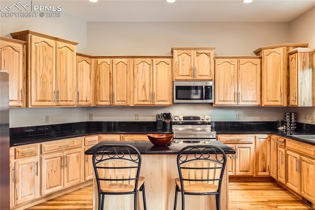 Image 13 of 50: Kitchen with recessed lighting, stainless steel appliances, a center island