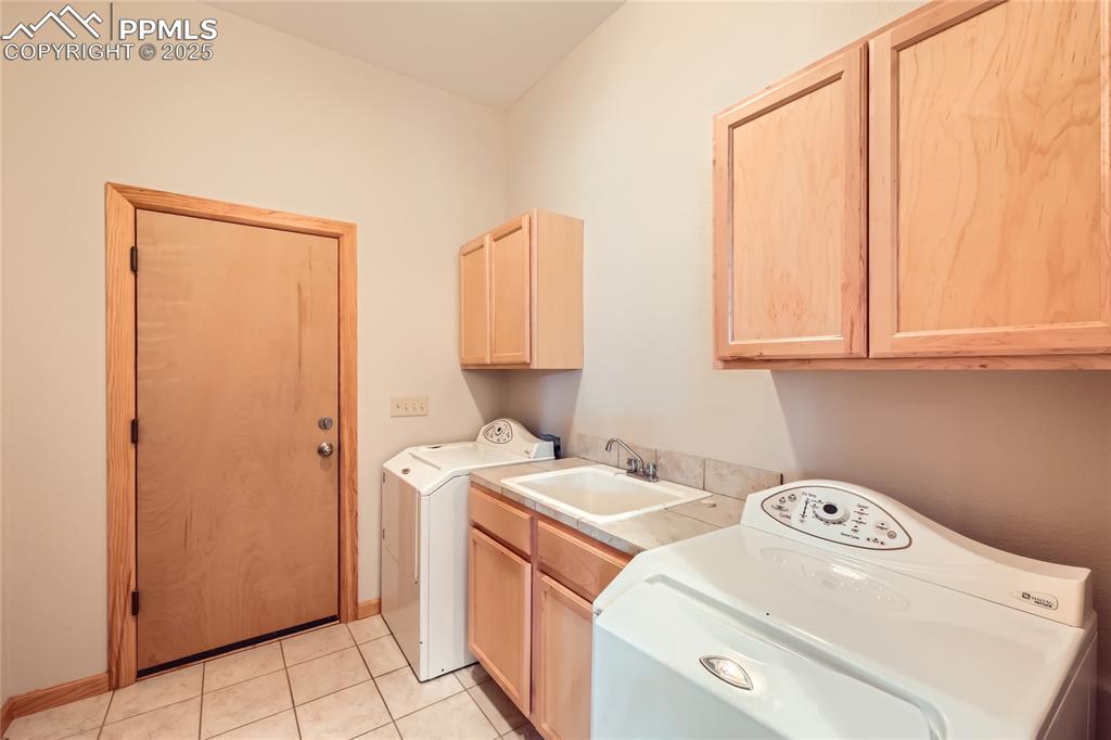 Image 15 of 50: Laundry room featuring washer and clothes dryer, light tile patterned floor